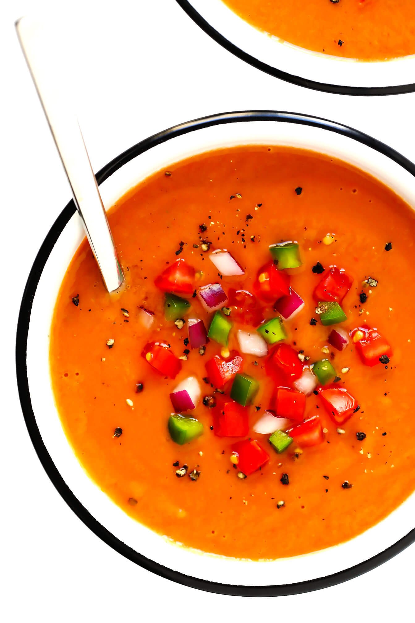 一碗西班牙凉菜汤，上面有番茄，青椒和红洋葱